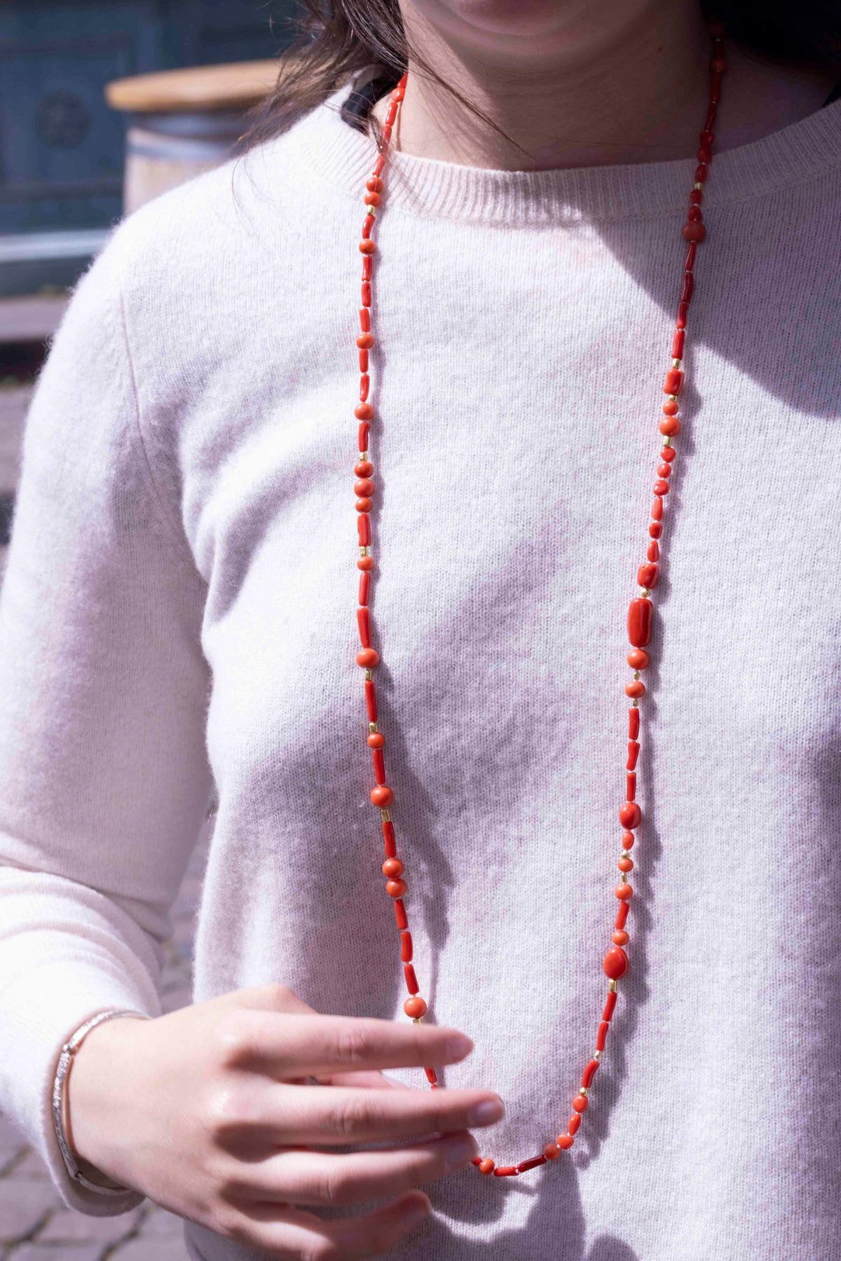 Rote Korallenkette mit Goldperlen lang um den Hals getragen, Sommerlook