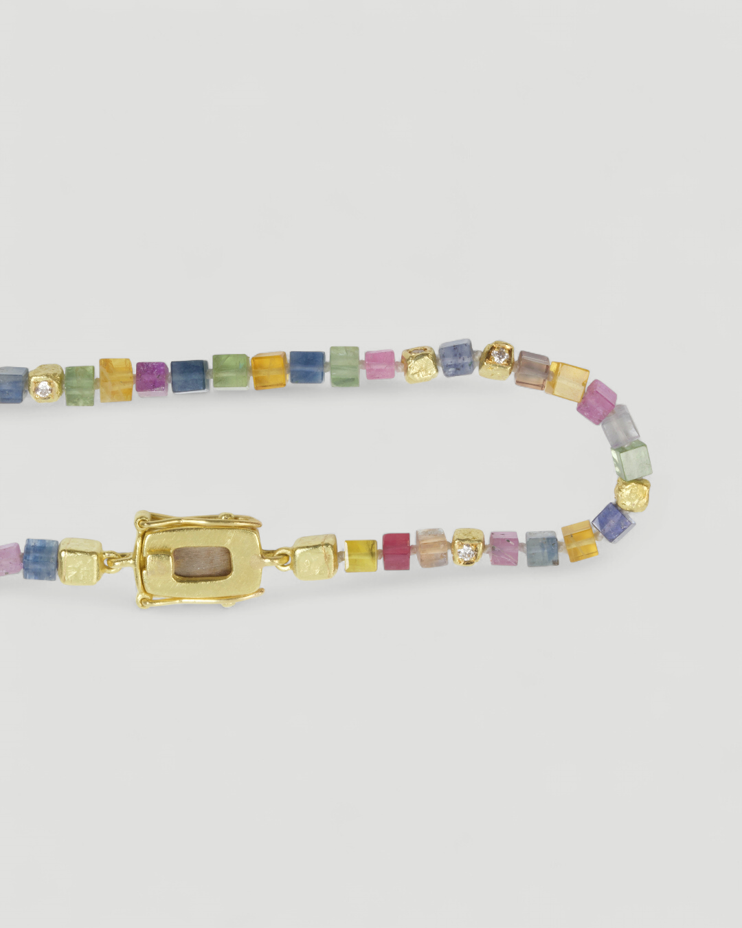 Bunte Saphirwürfel und Goldwürfel mit Brillanten am Armband, Nahaufnahme