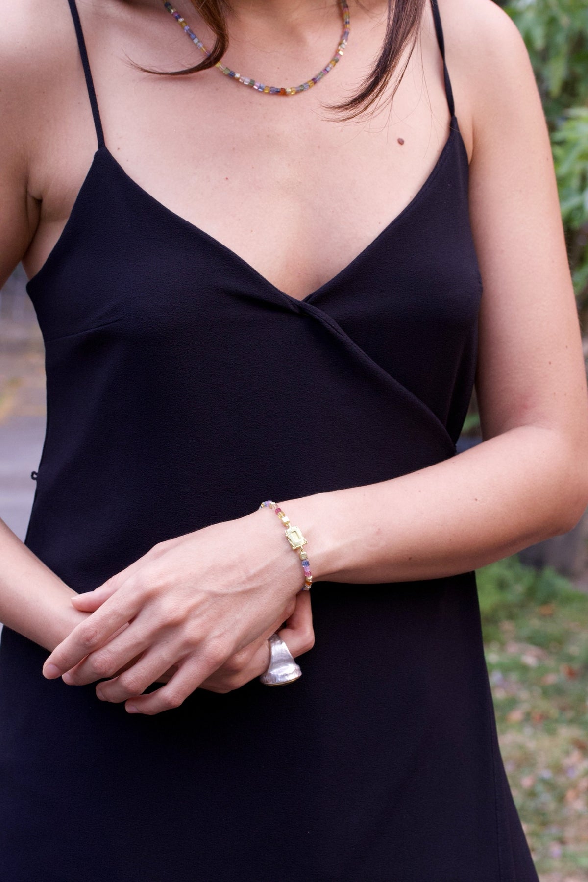 Buntes Saphirarmband und Saphirkette an einer Frau im schwarzen Kleid