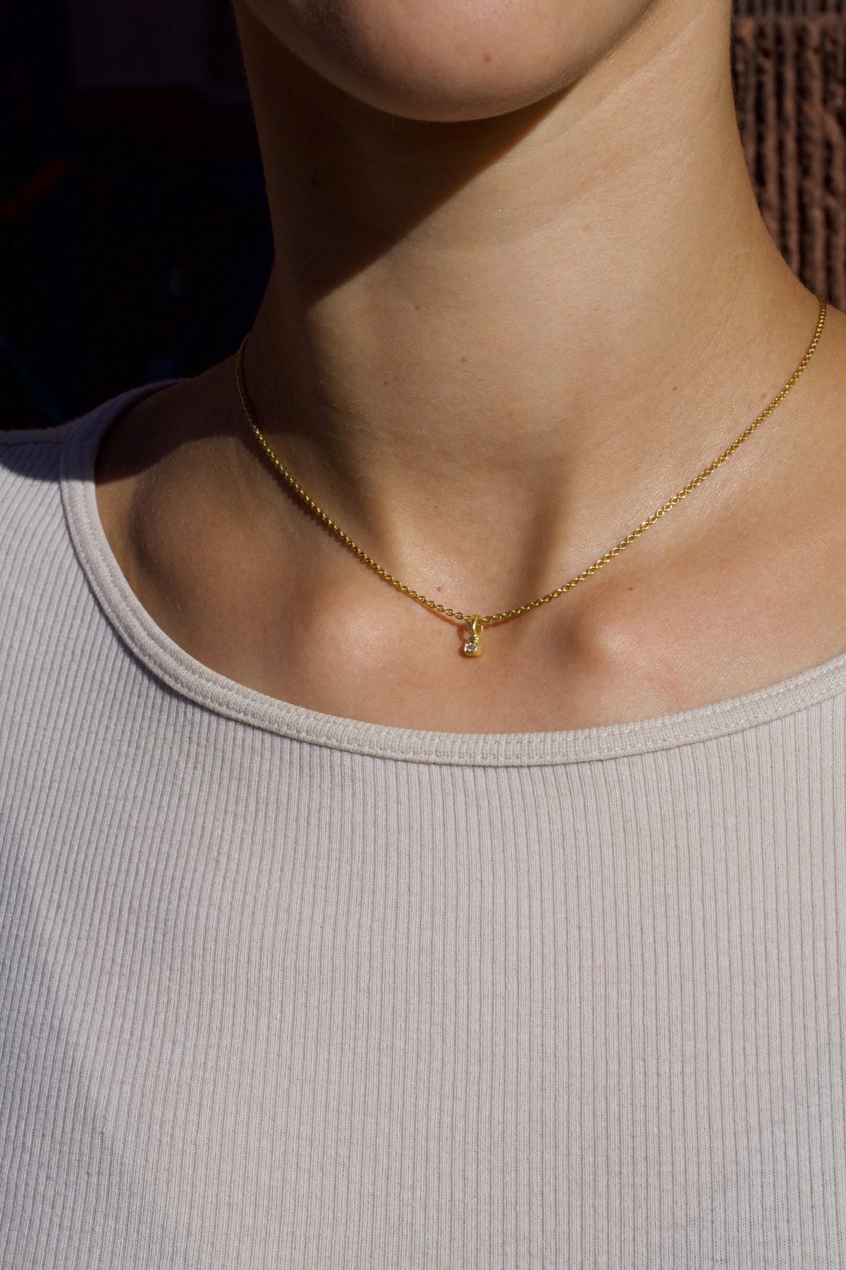 Zarter Würfelanhänger aus 750 Gold mit Lab Grown Diamant (0,02 ct) und 750 Goldkette, getragen