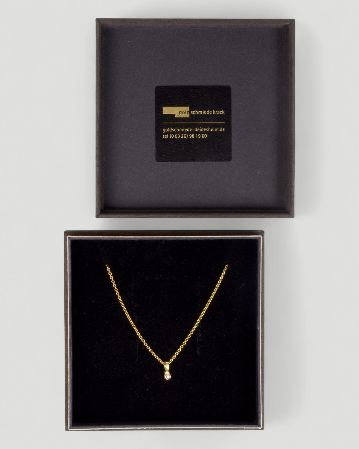 Zarter Würfelanhänger aus 750 Gold mit pinkem Saphir (0,03 ct) und 750 Goldkette, in der Schmuckbox