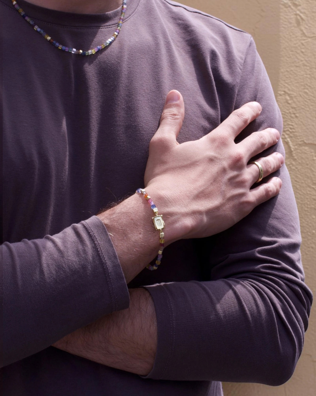 Buntes Saphirarmband am Arm getragen, Saphirkette im Hintergrund