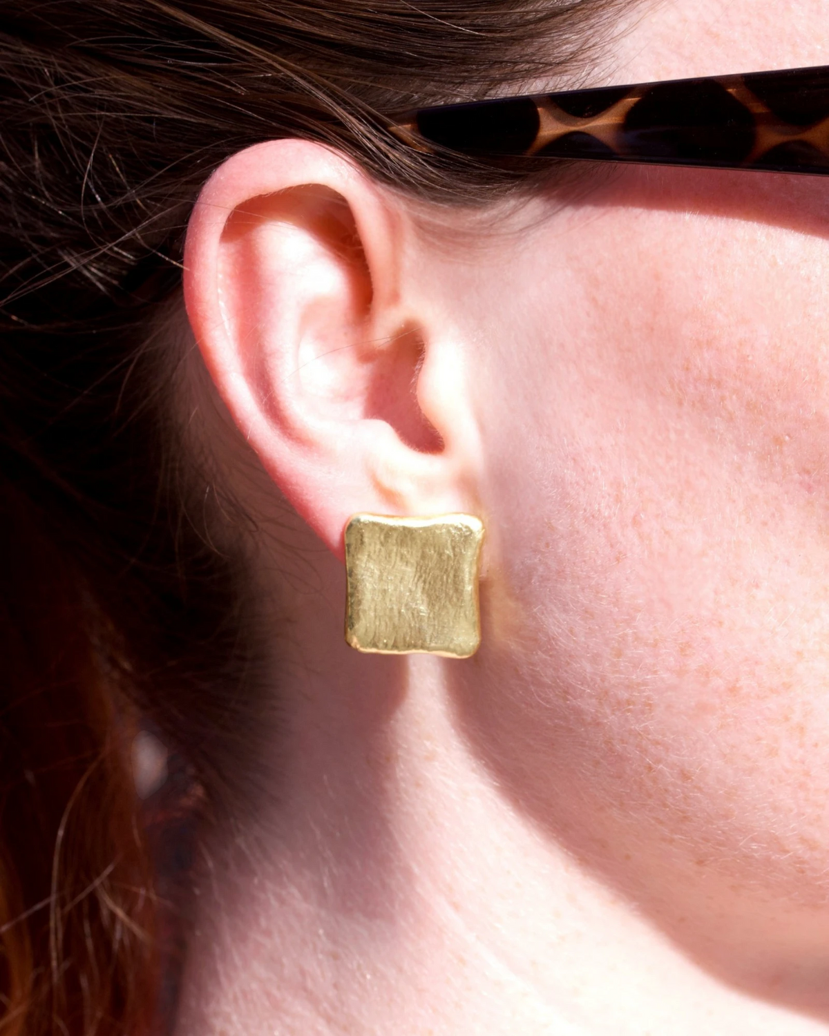 Eckiger Ohrschmuck aus 750 Gold am Ohr getragen, Nahaufnahme