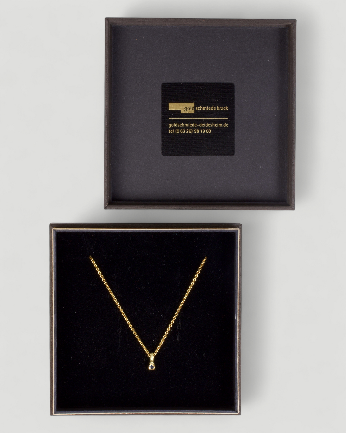 Zarter Würfelanhänger aus 750 Gold mit blauem Saphir (0,025 ct) und 750 Goldkette, in der Schmuckbox